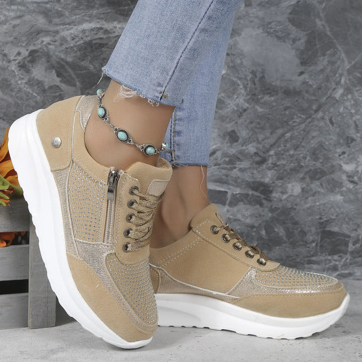 Beige suede platform sneakers with rhinestone details and zipper on side worn with light blue frayed jeans