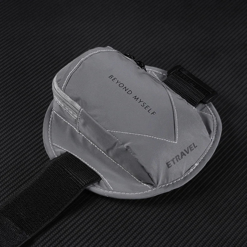 Gray ETRAVEL wrist pouch with zipper, elastic strap, and 'BEYOND MYSELF' text on black background.