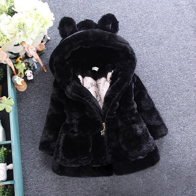 Black plush toddler jacket with bear ears hood on gray carpet background