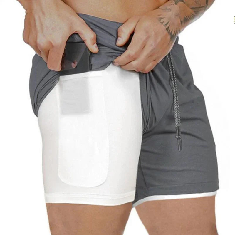 Man demonstrating hidden thigh pocket in gray athletic shorts holding a card with tattooed arm