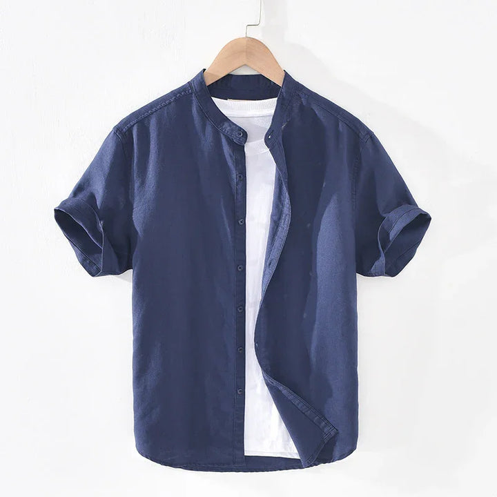 Navy blue short sleeve mandarin collar shirt layered over white t-shirt on wooden hanger