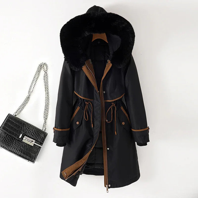 Black winter parka with brown trim and fur-lined hood next to black crocodile leather handbag