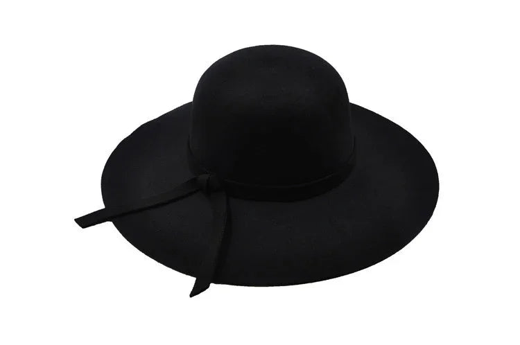Black wide-brimmed hat with rounded crown and decorative ribbon bow on side
