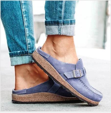 Casual slip-on blue suede shoes with buckle detail and cork soles worn with rolled-up jeans