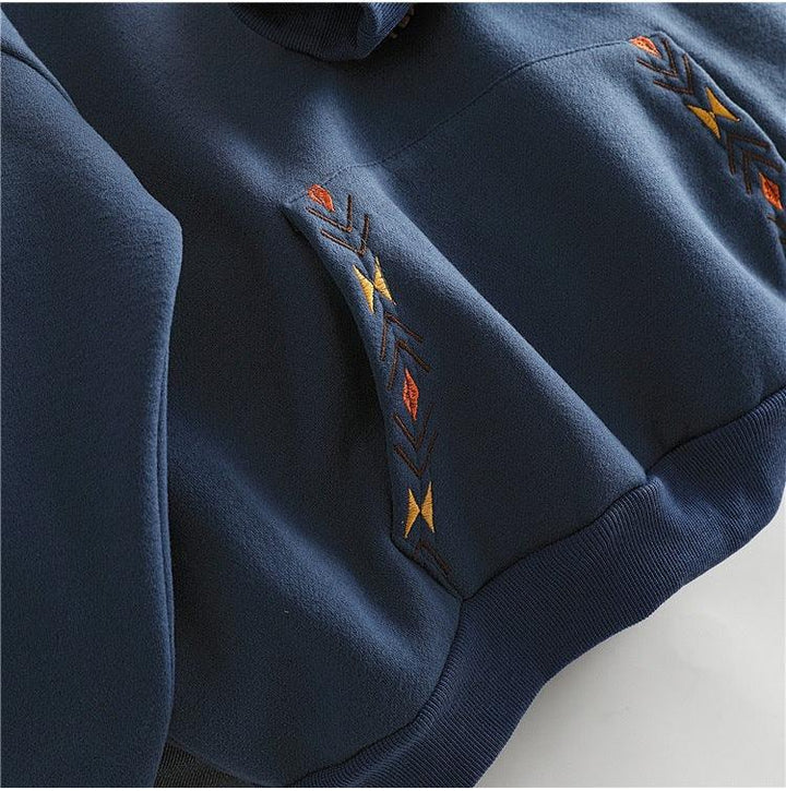 Navy blue hoodie fabric with colorful geometric embroidery detail in orange, yellow, and brown