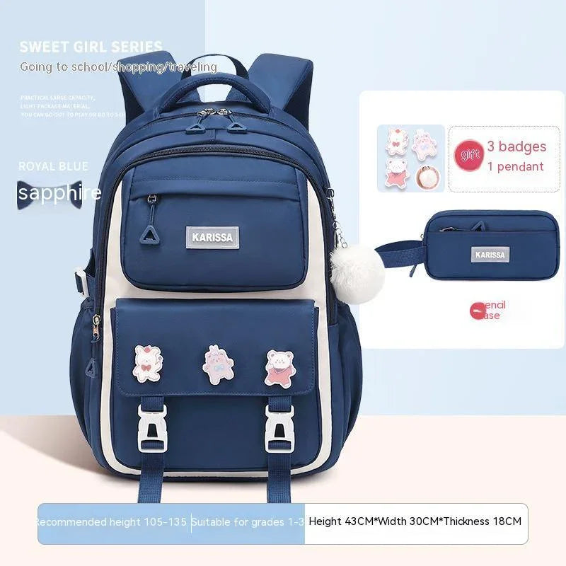 Royal blue Karissa backpack with white accents, three cartoon badges, and matching pencil case for school