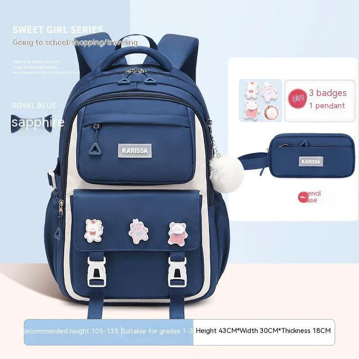 Royal blue Karissa backpack with white accents, three cartoon badges, and matching pencil case for school