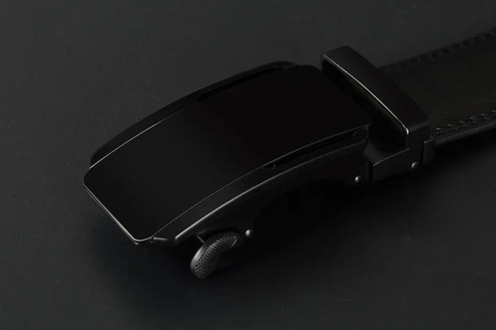 sleek black automatic ratchet belt buckle on a black leather strap with textured adjustment wheel