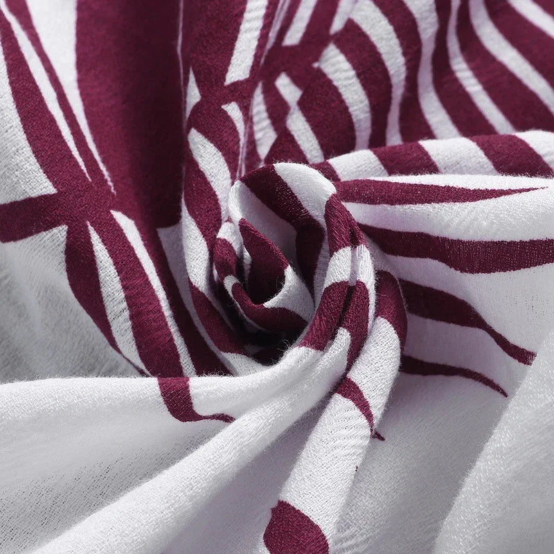 Close-up of white fabric with maroon abstract stripes and soft, textured material