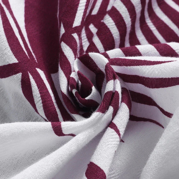 Close-up of white fabric with maroon abstract stripes and soft, textured material