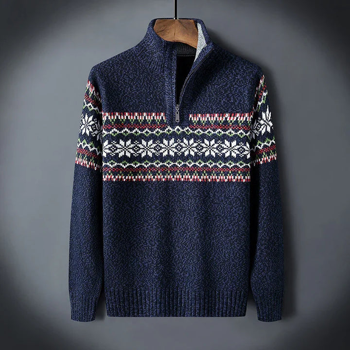 Navy blue knit sweater with half zipper and white snowflake pattern across chest and sleeves