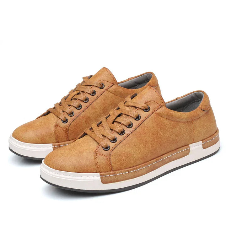 Pair of tan casual leather sneakers with brown laces and white rubber soles