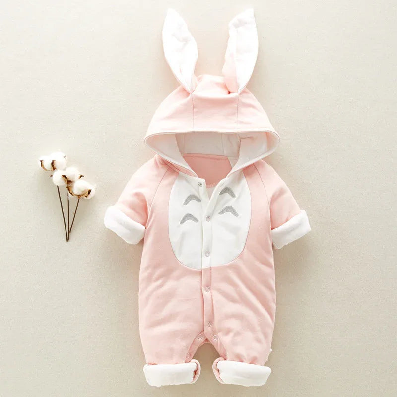 Soft pink baby romper with hood and bunny ears, white front panel, and rolled cuffs on neutral background