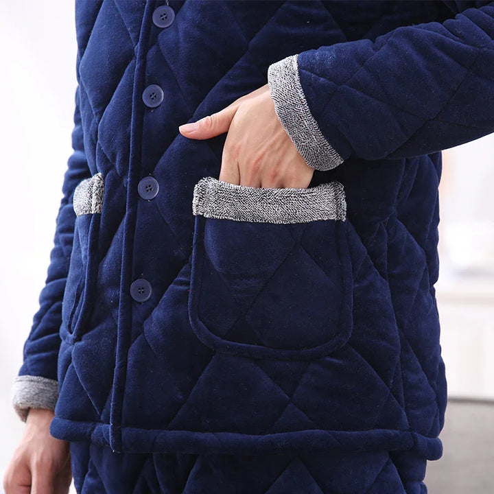 Person wearing navy blue quilted jacket with grey cuff and pocket trim, hand inside front pocket