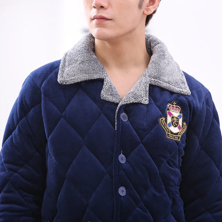 Man wearing navy quilted jacket with gray textured collar and embroidered crest badge