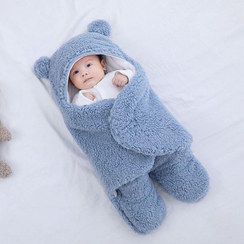 Infant wrapped in a soft blue fleece baby swaddle blanket with bear ears on hood
