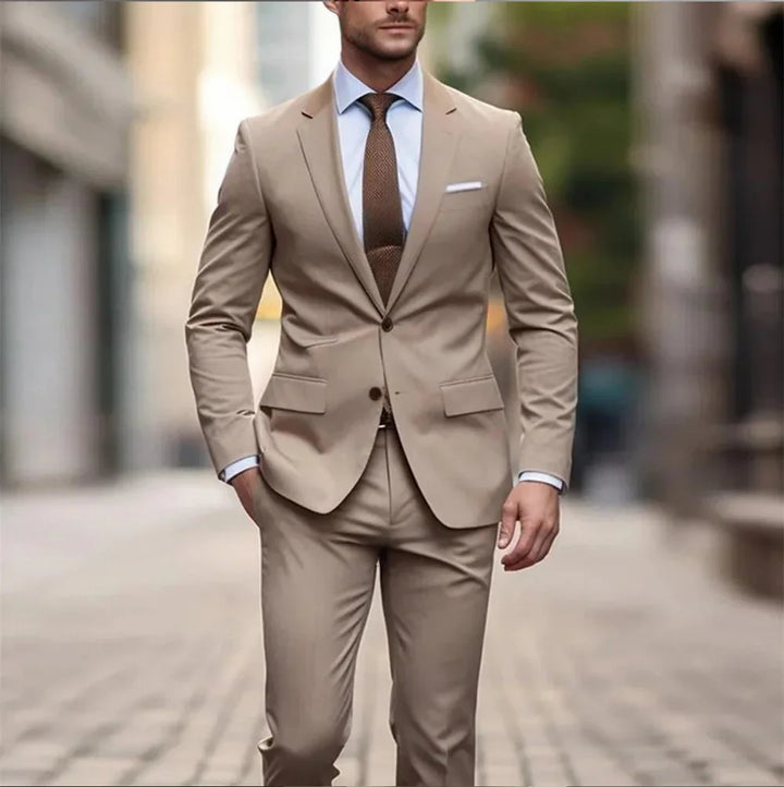 man in beige slim-fit suit with blue shirt and brown tie walking on cobblestone street