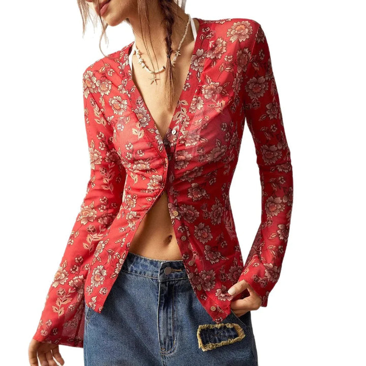 Woman wearing red floral long-sleeve button-up top with blue jeans and layered necklaces