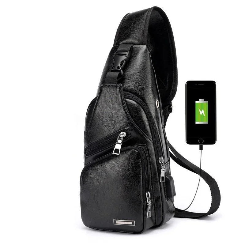 Black leather sling bag with multiple zippered compartments and USB charging port connected to smartphone