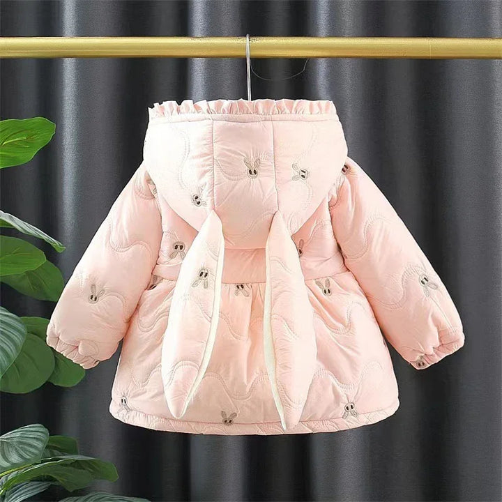 Pink baby winter jacket with bunny ears hood and quilted pattern hanging on wooden rod