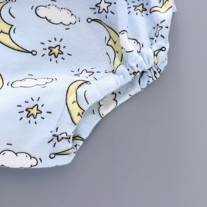 Close-up of blue baby cloth diaper with moon, stars, and cloud pattern on gray background