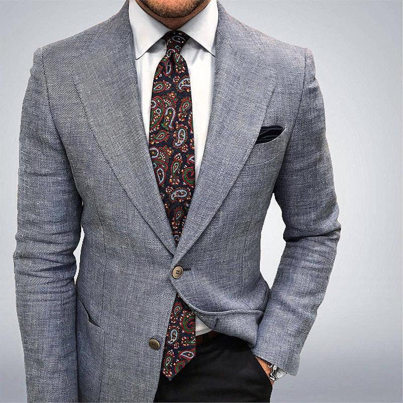 man wearing light gray herringbone blazer with white shirt and colorful paisley tie