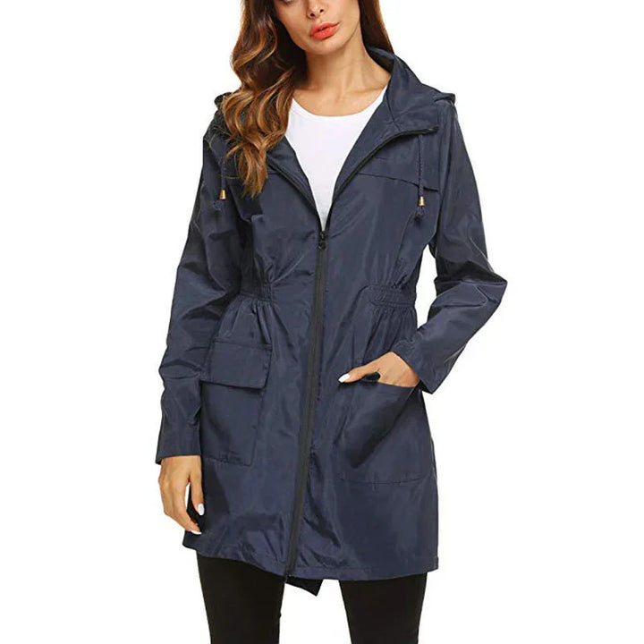Woman wearing navy blue lightweight hooded raincoat jacket with front zipper and pockets