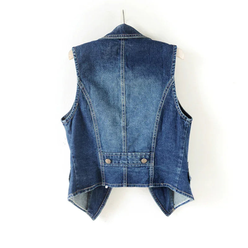 Back view of blue denim vest with pointed hem and buttoned waist tab on hanger