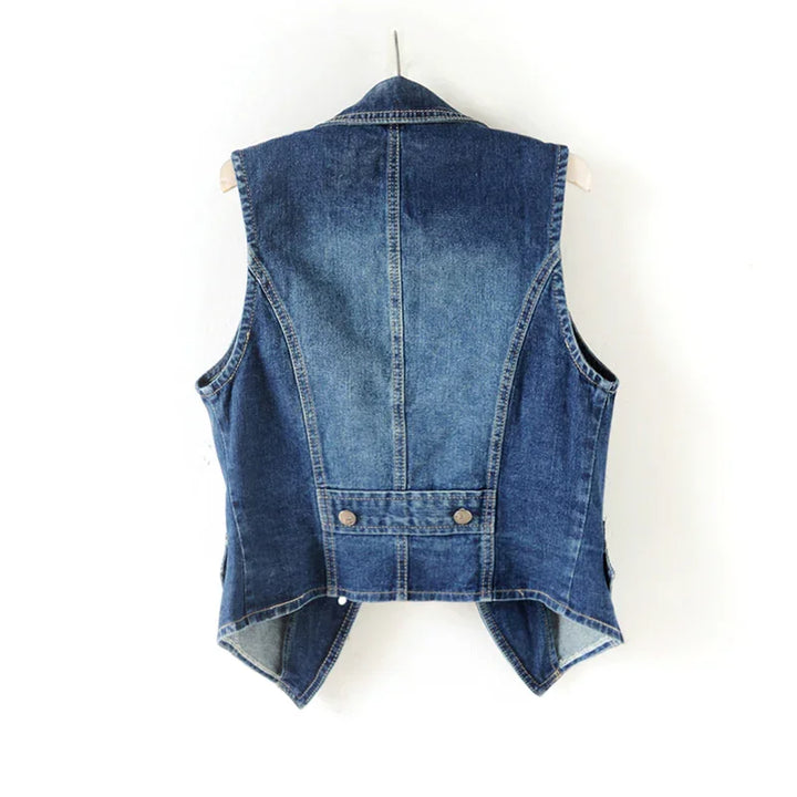Back view of blue denim vest with pointed hem and buttoned waist tab on hanger