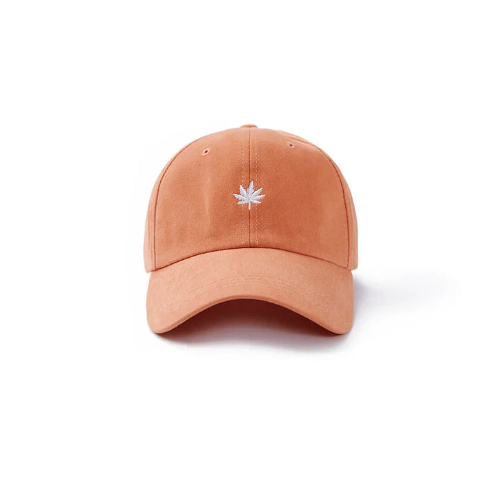 Orange baseball cap with white embroidered cannabis leaf logo on front against white background