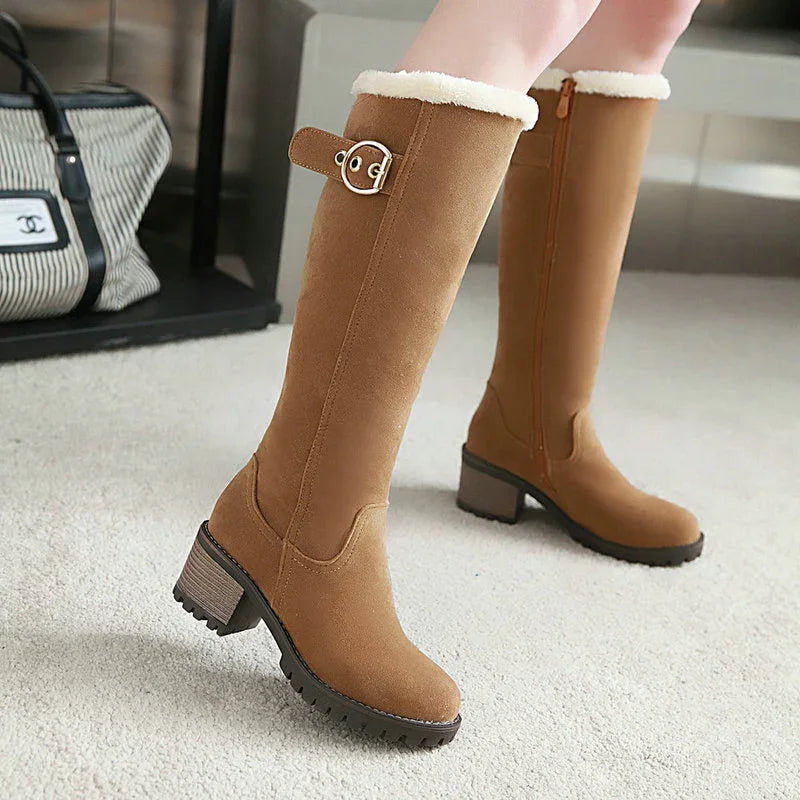 Women wearing knee-high tan suede boots with faux fur lining and buckle detail on carpet