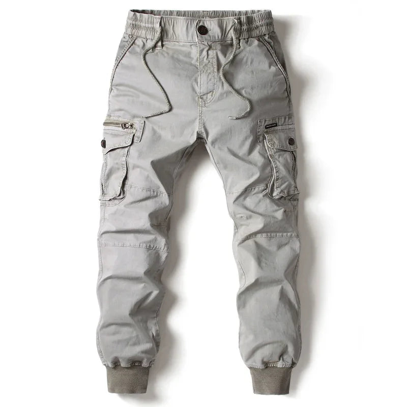Light gray cargo jogger pants with elastic cuffs, front pockets, drawstring waist, and zipper detail