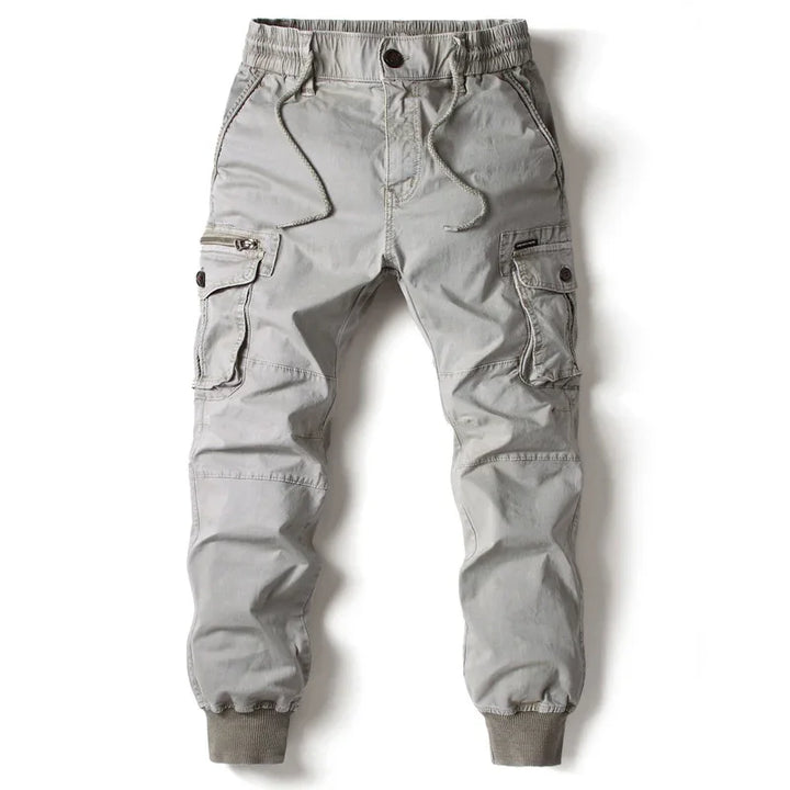 Light gray cargo jogger pants with elastic cuffs, front pockets, drawstring waist, and zipper detail