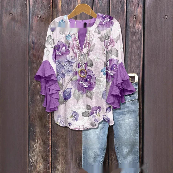 Floral blouse with purple ruffled sleeves paired with blue jeans on wooden background