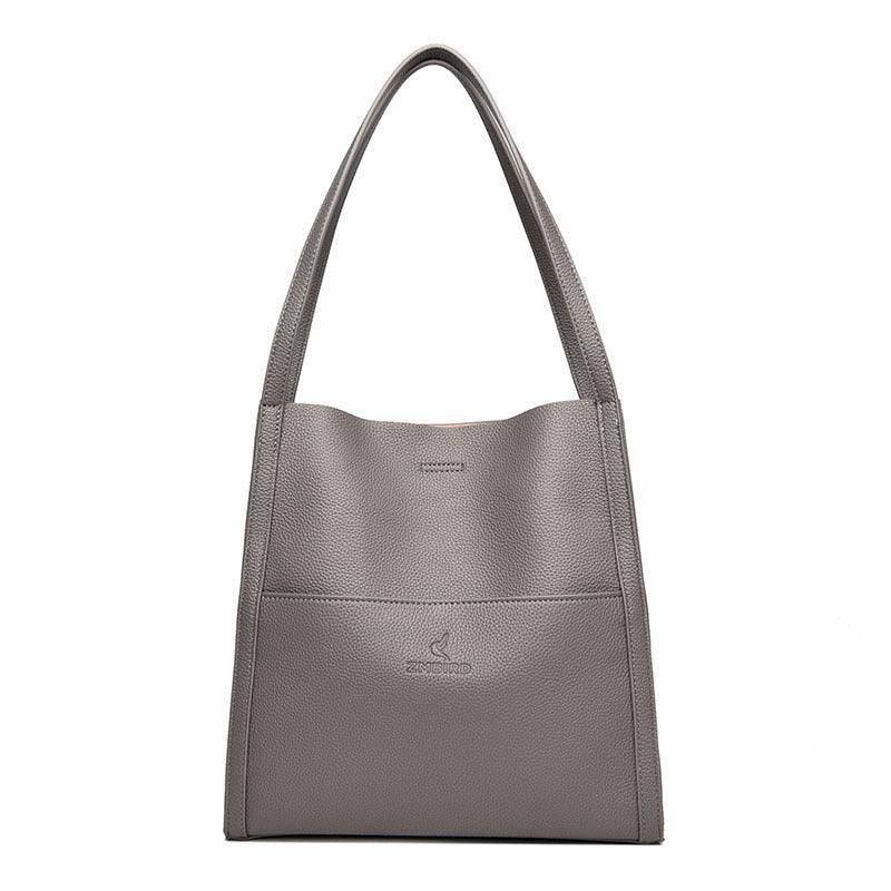 Gray textured leather tote bag with shoulder straps and embossed brand logo on front pocket