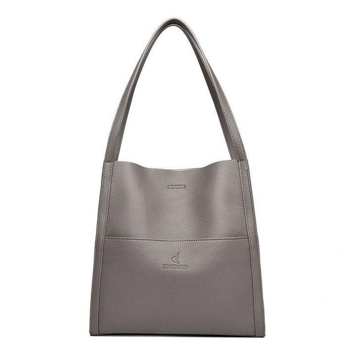 Gray textured leather tote bag with shoulder straps and embossed brand logo on front pocket