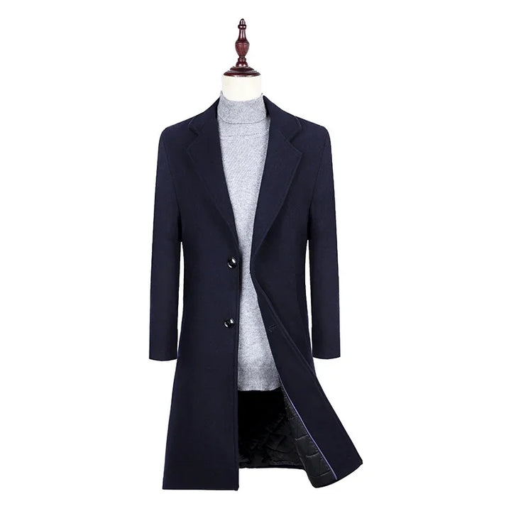 Men's navy blue overcoat with black buttons layered over a light gray turtleneck sweater on a mannequin