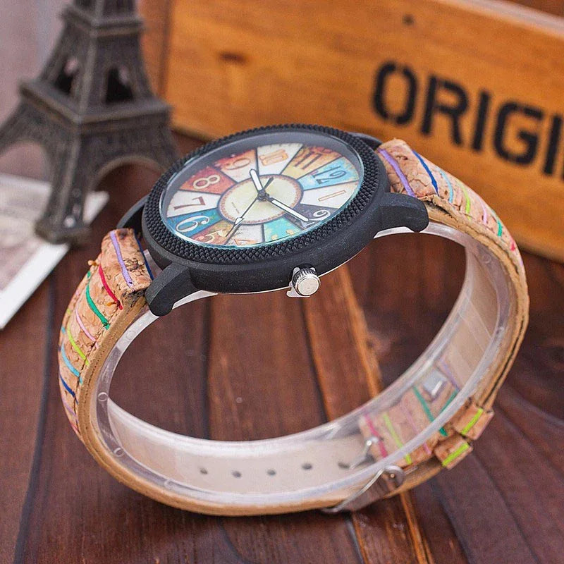 Colorful analog wristwatch with multicolor numbered dial and cork strap on wooden table