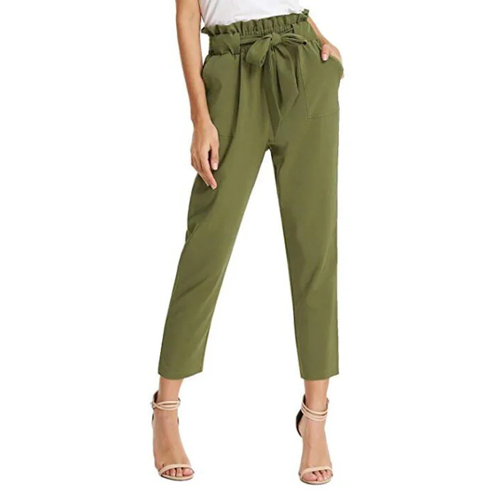 Woman wearing olive green high-waisted paperbag pants with tie belt and pockets