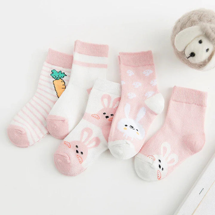 Set of five pastel pink and white baby socks with bunny faces, carrot, and polka dot patterns