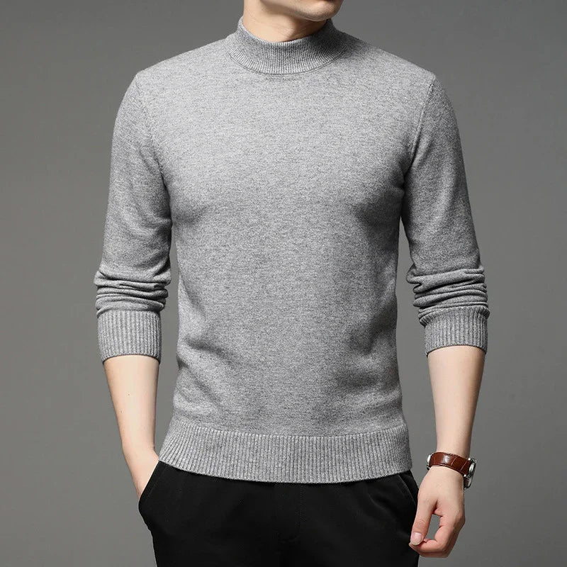 Man wearing a light gray ribbed knit sweater with long sleeves and black pants