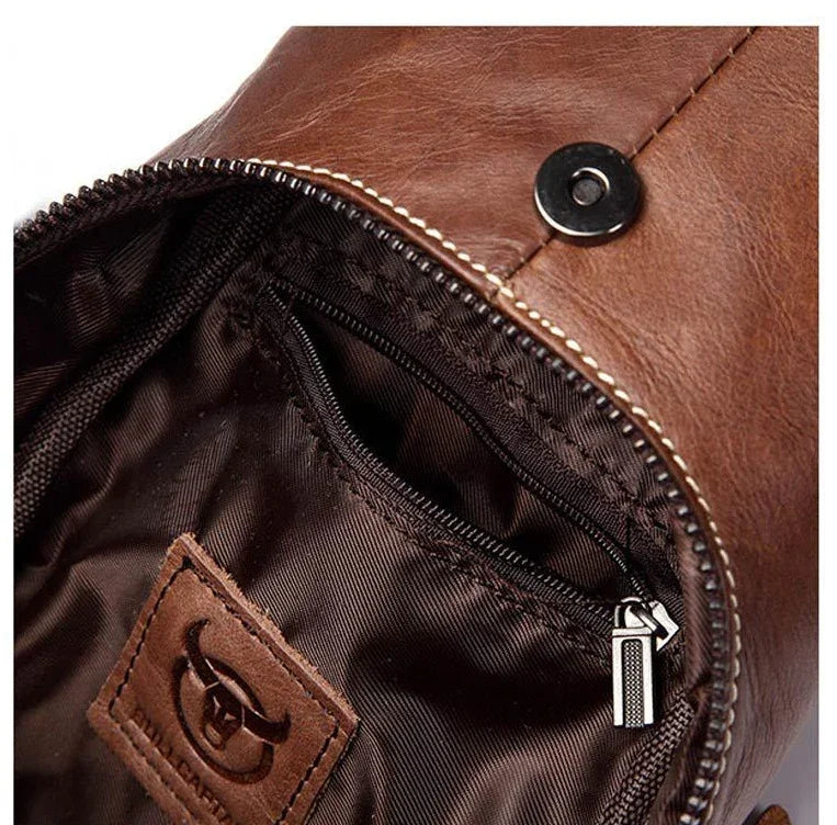 Close-up of brown leather bag interior with zippered pocket and branded leather patch
