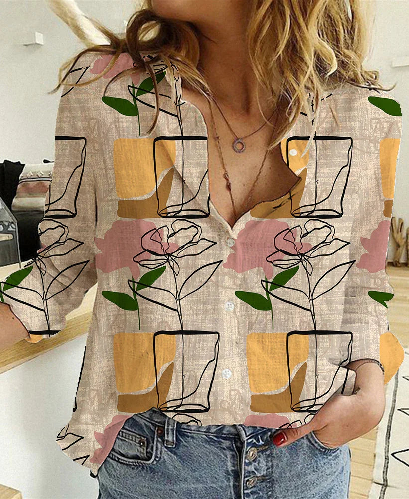 Woman wearing casual button-up shirt with abstract floral and geometric pattern, paired with blue jeans