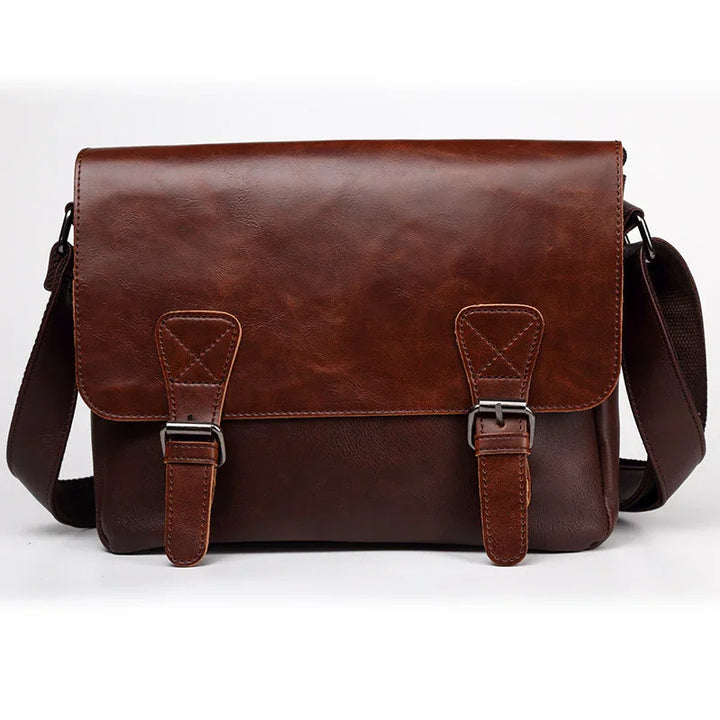 brown leather messenger bag with front buckles and adjustable shoulder strap on white background