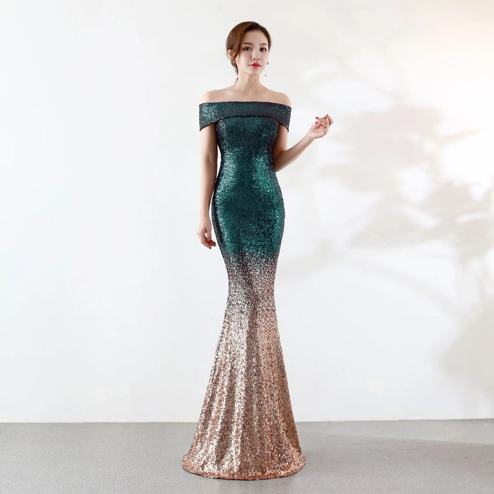 Woman wearing a sequined off-shoulder mermaid gown in green and gold gradient on plain background