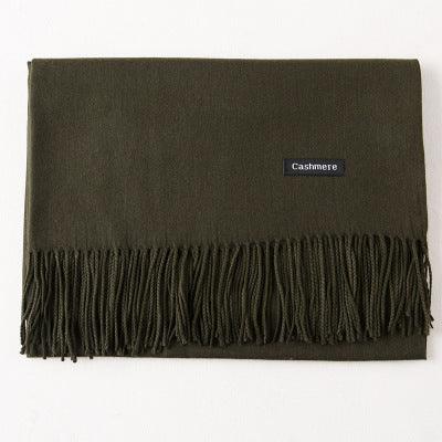 Folded olive green cashmere scarf with fringed edges on white background