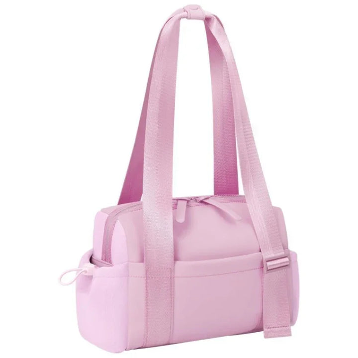 Light pink insulated lunch bag with long handles, zippered top, and side pockets