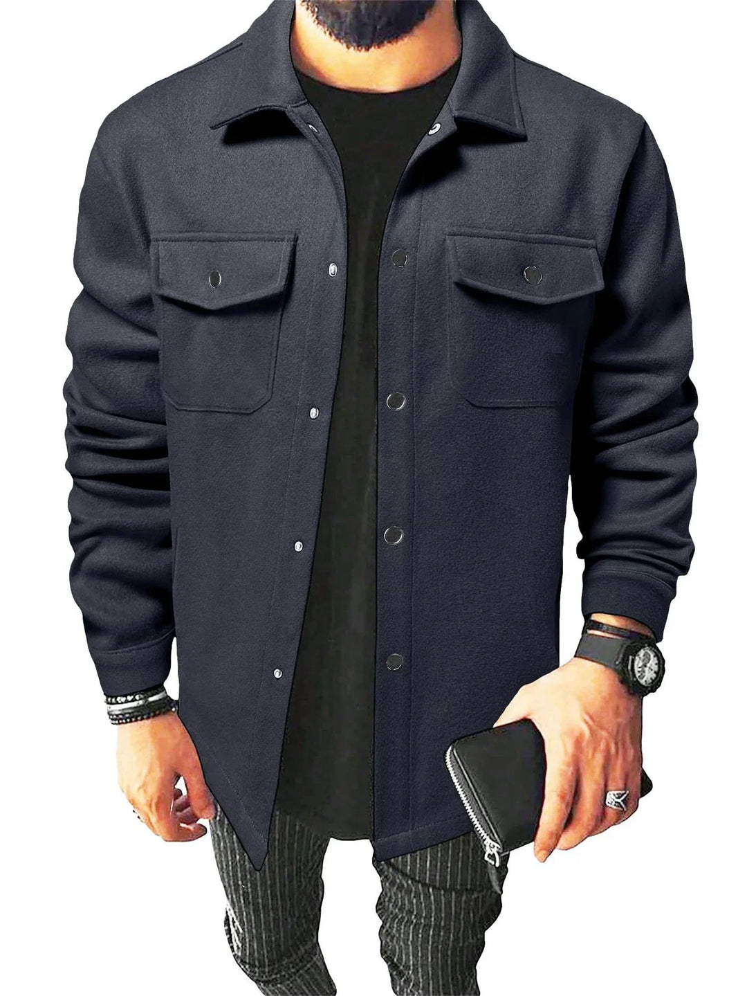Man wearing black button-up shirt jacket with chest pockets, black tee, striped pants, and accessories