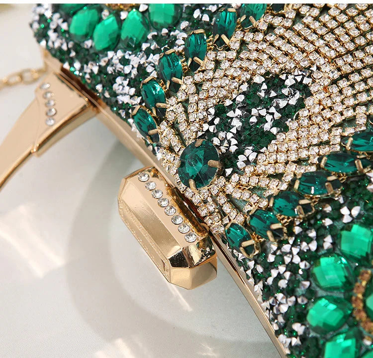 Close-up of gold clutch bag with green and clear crystal embellishments and rhinestone clasp