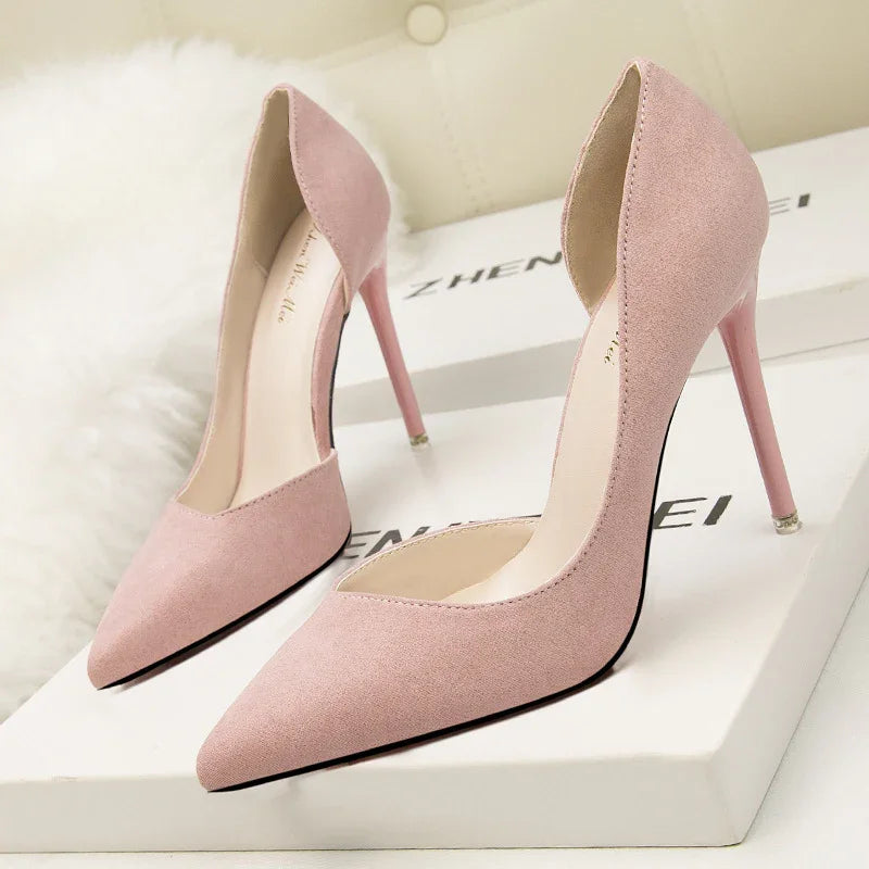 Pair of elegant pink suede high heels with pointed toes on white branded boxes